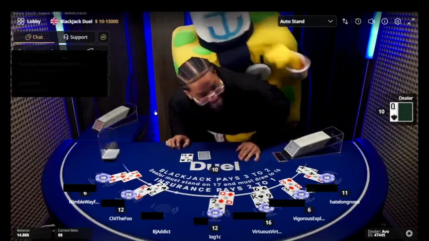 A yellow costume with green spots standing behind the host at the Duel Blackjack table on 9 May 2026