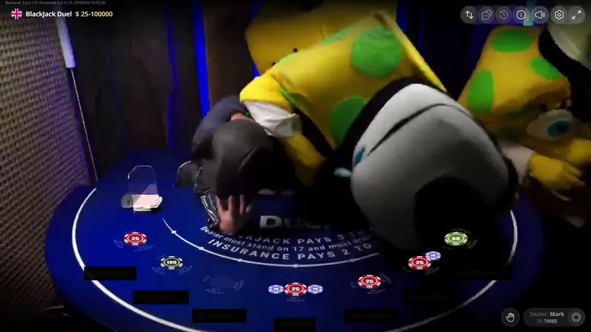 Two yellow costume heads visible together behind a third body bent over the Duel Blackjack layout